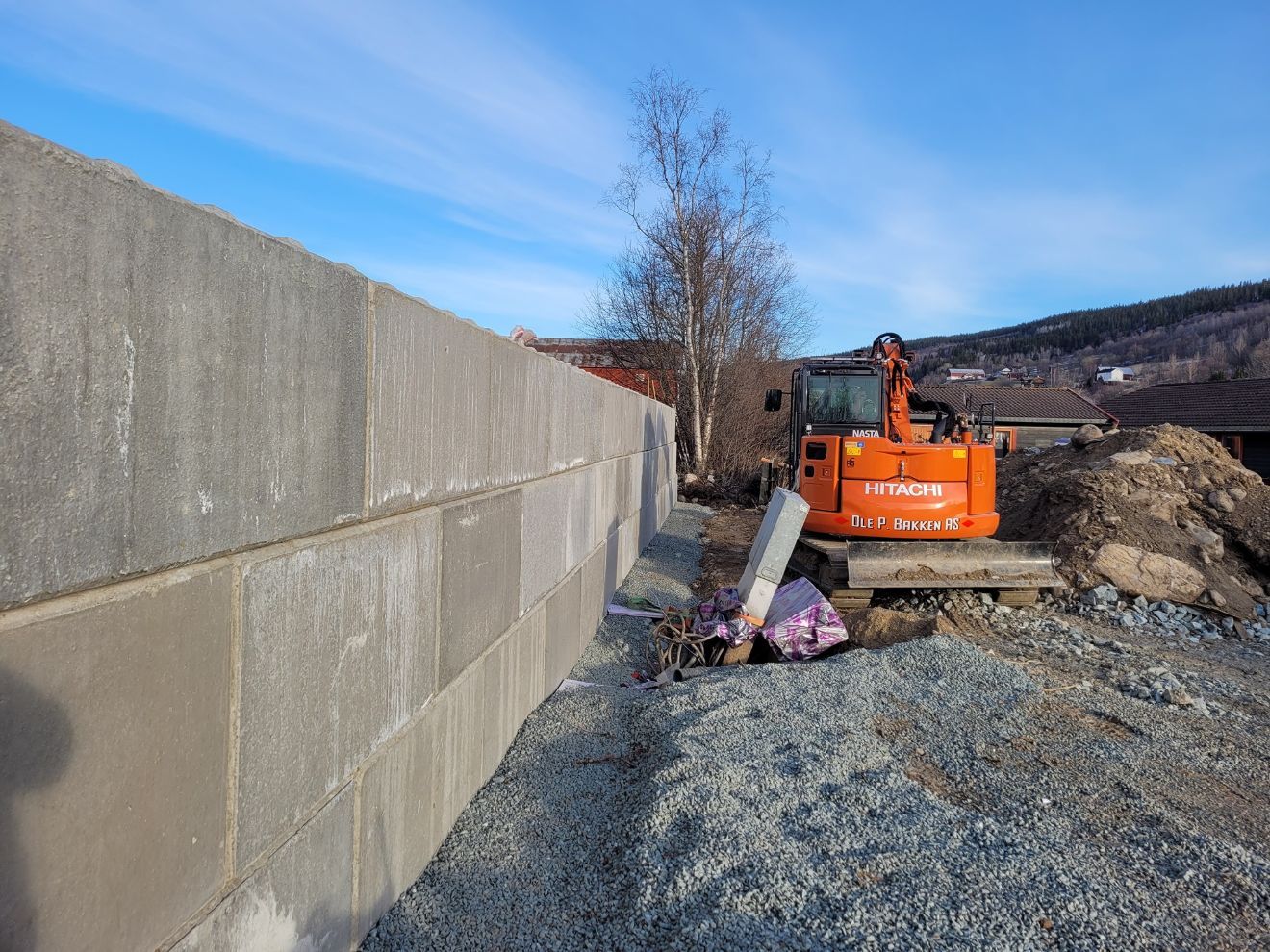 Betongmur og gravemaskin