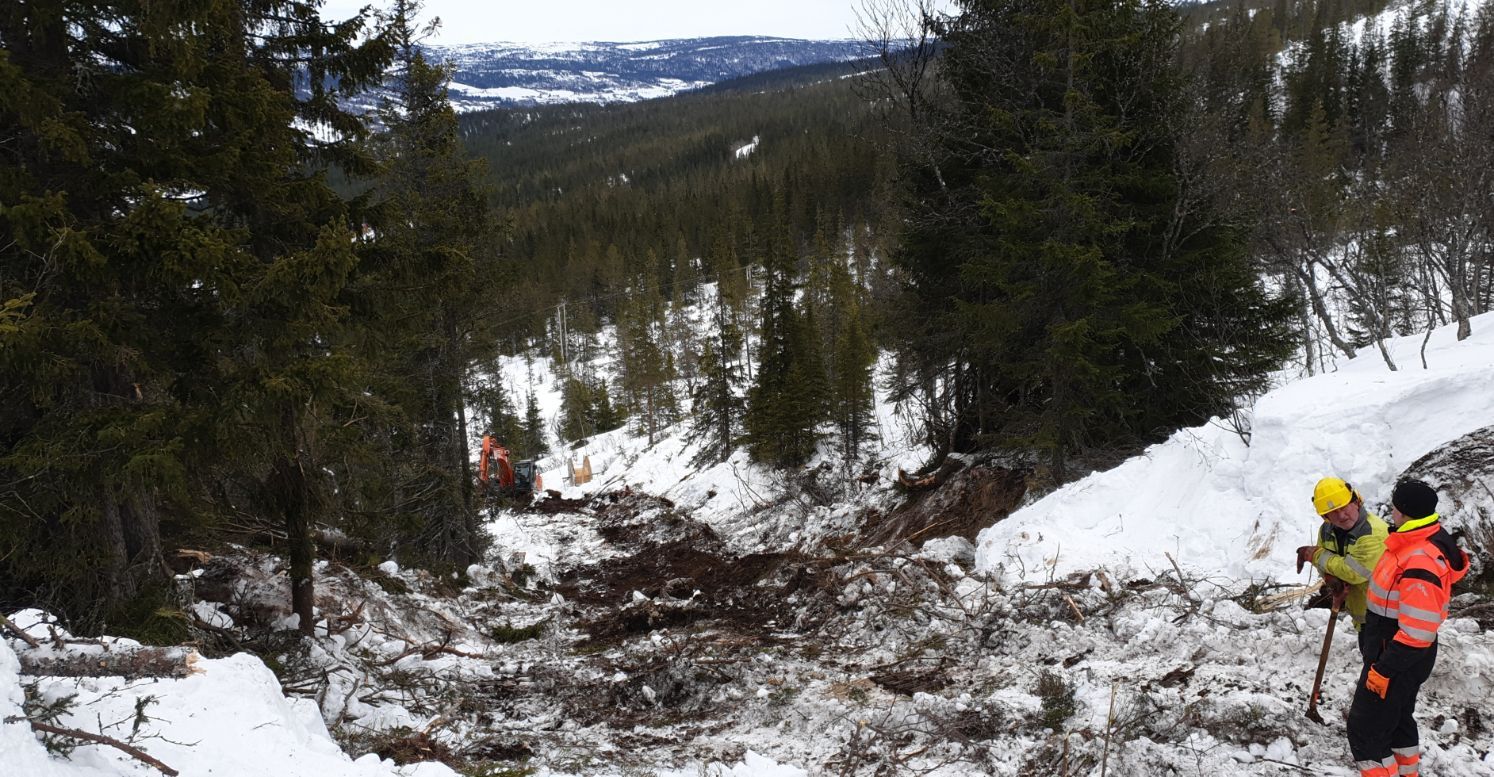 Graving av vei i snødekt skog