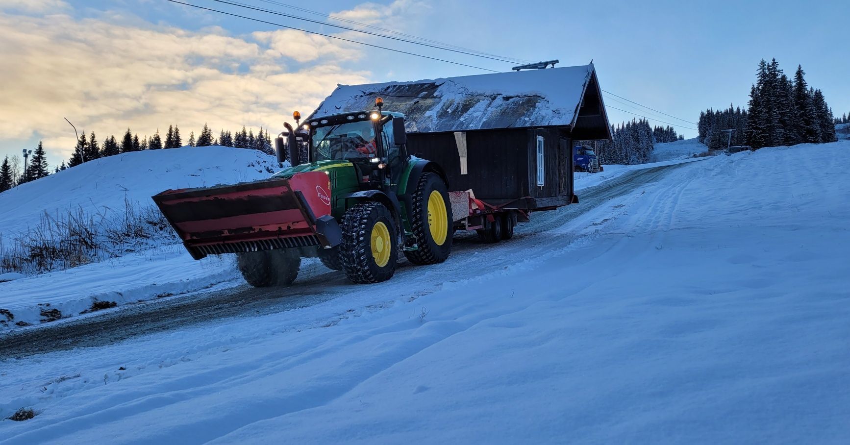 Traktor med lite hus på lasteplan