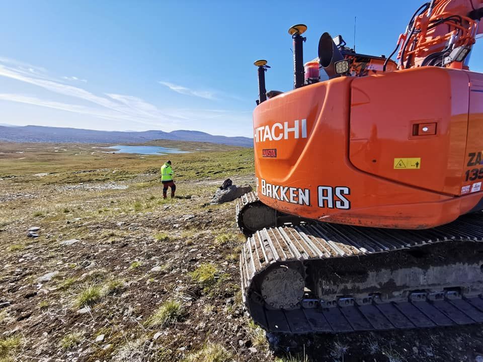 Gravemaskin i flatt fjellområde