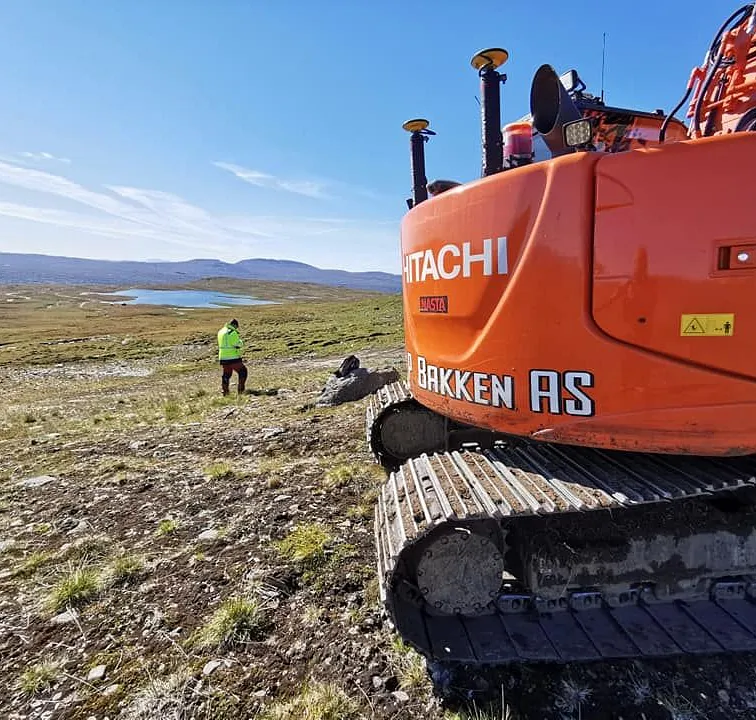 Gravemaskin i flatt fjellområde
