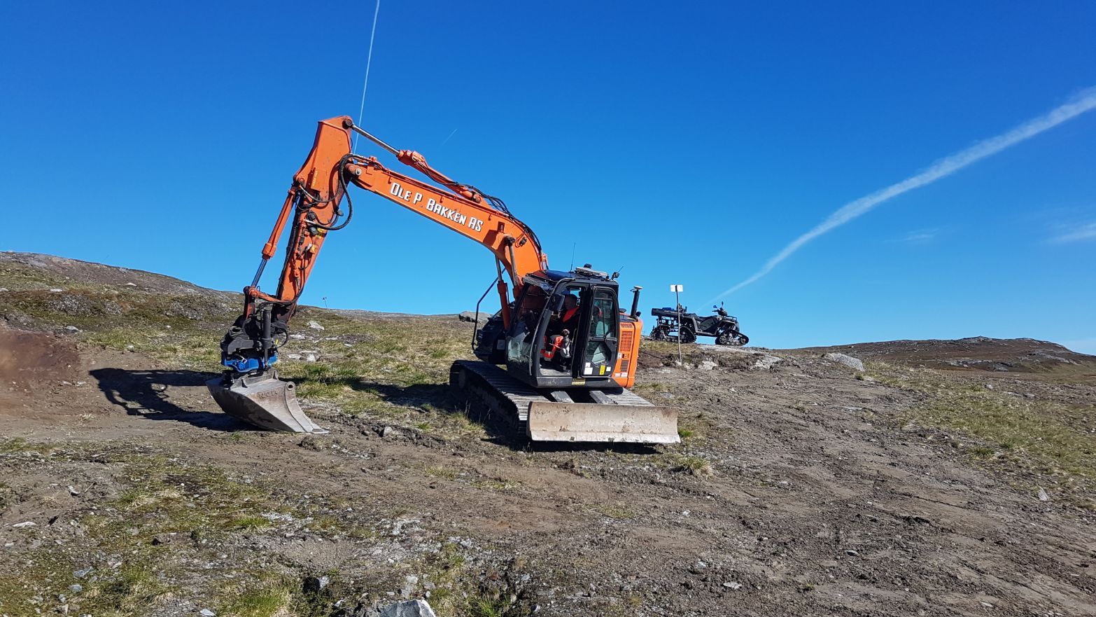 Gravemaskin parkert i fjellområde